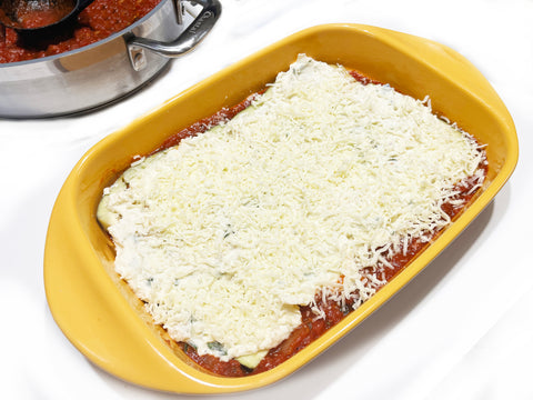 add cheese to eggplant lasagna in marigold ceramic baker