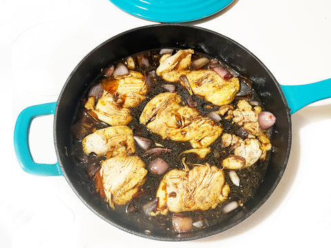 chicken back in pan before oven in sea blue cast iron skillet