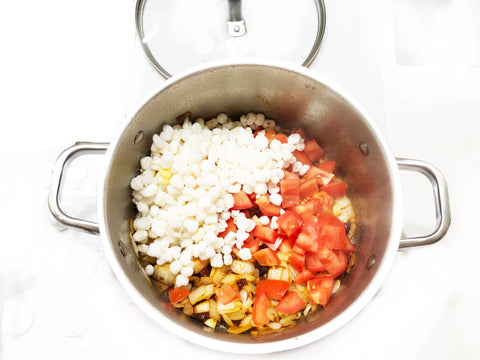 agregue los tomates molidos y el ajo a las tiras chantal de una olla de 6 cuartos de galón