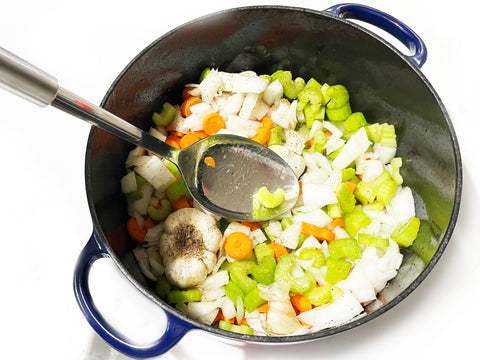 celery carrots and onions cooking with garlic heads