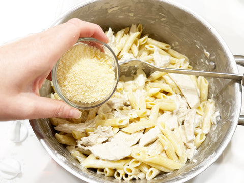 agregue parmesano a la pasta alfredo en una olla de acero inoxidable de inducción 21 de 6 cuartos con inserto para vaporera