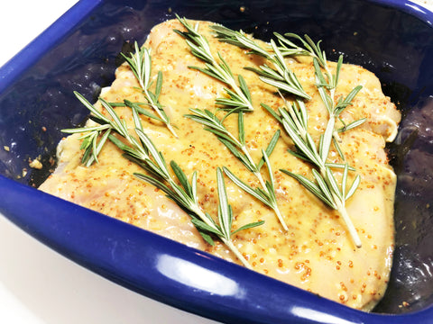 honey mustard chicken strips in square oven dish with sauce and rosemary on top