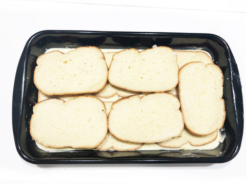arranging bread layers in riess enamel on steel casserole dish for french toast oven bake