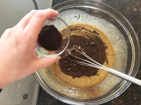 agregue los posos de café al tazón para mezclar el pastel de chocolate en un molde para pastel hondo