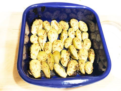 baked brussel sprouts in honey mustard sauce in enamel on steel blue square oven dish