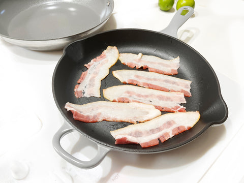 cooking bacon in grey cast iron skillet