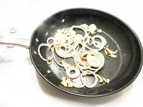 onions and garlic cooking in kitchengear fry pan for chicken strips