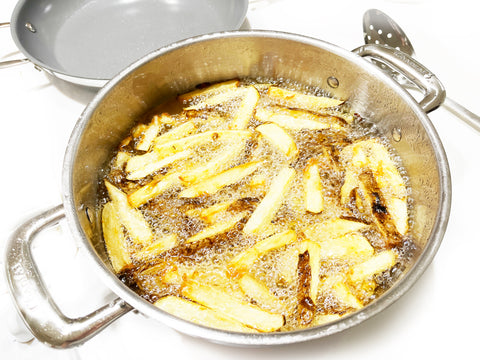freír patatas en aceite en la sartén del chef