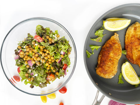 chicken milanese in 3 clad saute pan and chickpea salad in glass bowl