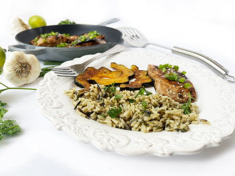 bourban glazed salmon wild rice and acorn squash on plate with grey cast iron skillet 