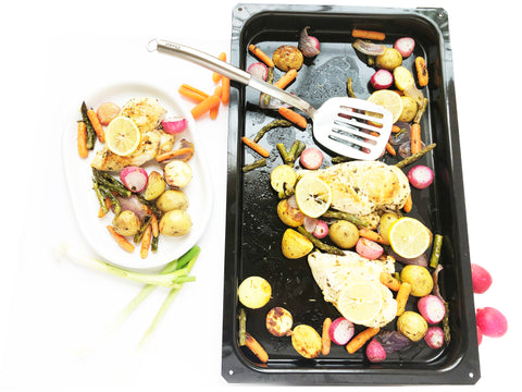 plate of chicken and vegetables radishes potatoes carrots onions and spatula enamel on steel bake tray