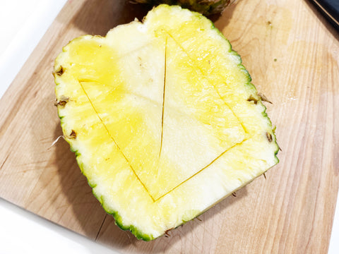 cutting x in pineapple to help scoop out for chicken teriyaki bowls