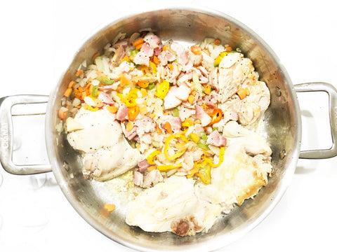 mezclando verduras, tocino y pollo en sateuse 3 revestidos de 5 cuartos para la receta de cassoulet