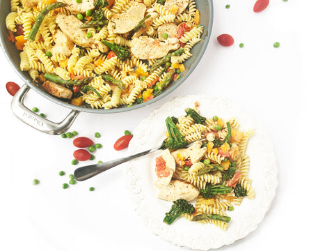 close up image of chicken pasta primavera plated and in 12 and a half inch ceramic coated fry pan