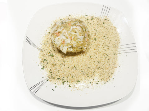 coat crab cakes in breadcrumbs on plate