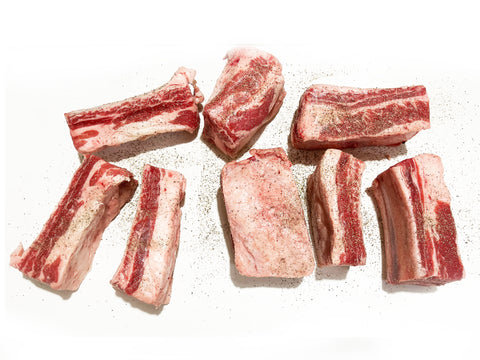 season short ribs on counter with salt and pepper