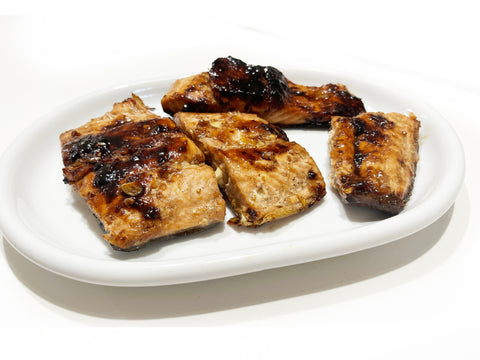 bourbon glazed salmon fillets on white plate after cooking