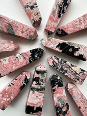 image shows pink and grey rhodonite points arranged in a circular formation