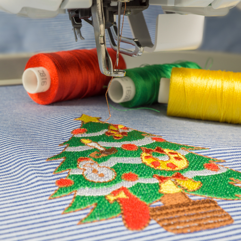 Machine embroidery sample Christmas tree on blue and white striped fabric