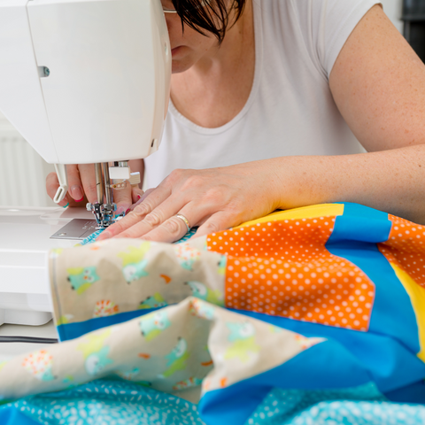 Woman sewing a quilt at a machine