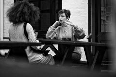 Two women having a conversation at a picnic table