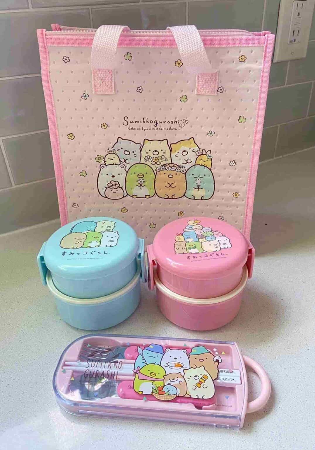 https://cdn.shopify.com/s/files/1/0528/2060/7157/products/clever-idiots-bento-sumikko-gurashi-round-bento-lunch-box-with-fork-38190559428822.jpg?v=1662659118&width=1076