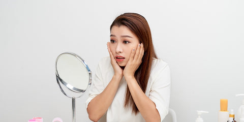 Woman looking the mirror surprised 