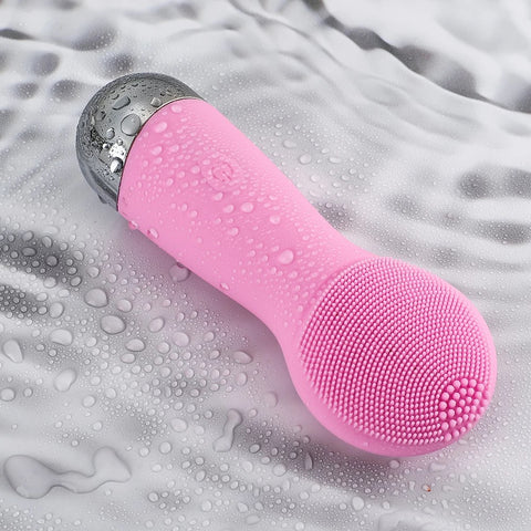 Pink Sonic Face Cleansing Brush lies on wet surface