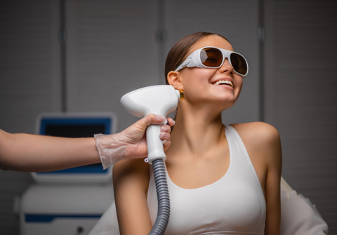 Woman smiles as a laser machine is placed near ear