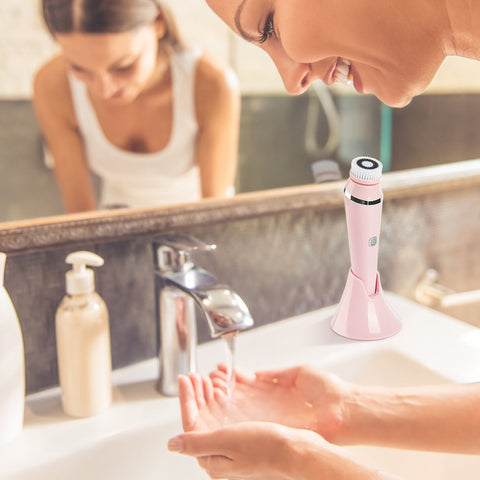 Woman Using Sink Prepares to Use Facial Cleansing Brush Pink
