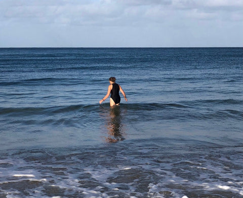 Open water swimmer walking into the sea