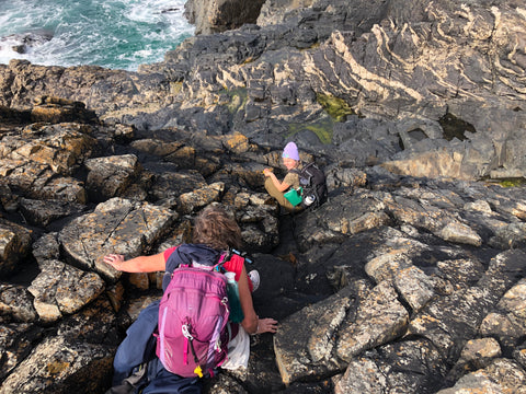 Laura Evans the St Ives Mermaid clambering down rocks on Wild Body Walks in Cornwall UK