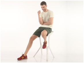 man sitting on a chair wearing almo t-shirt and green almo shorts