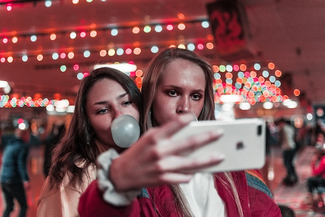 2 filles se prenant en selfie en faisant une bulle avec leur chewing gum