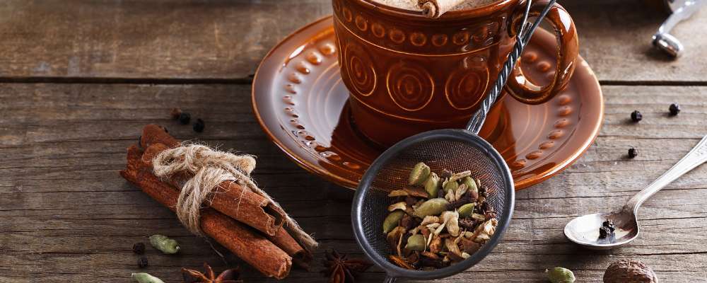 Aromatic cup of chai with spices scattered around