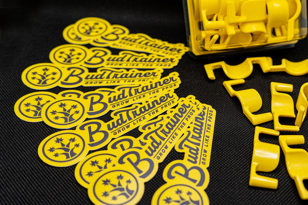 BudClips and BudTrainer stickers on a black table top