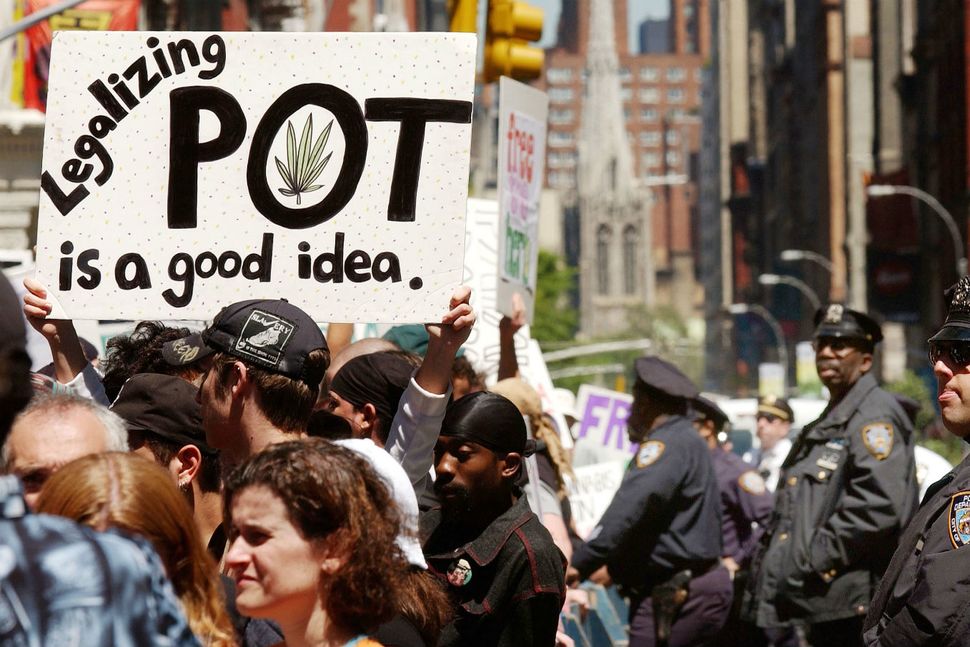 Cannabis sign saying "legalizing pot is a good idea" being help up high by a protester in Canada.