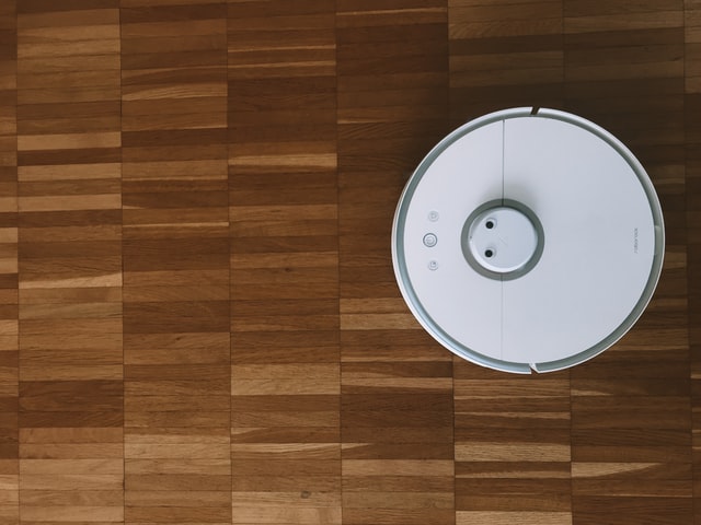 Roomba blanc sur un plancher de bois franc