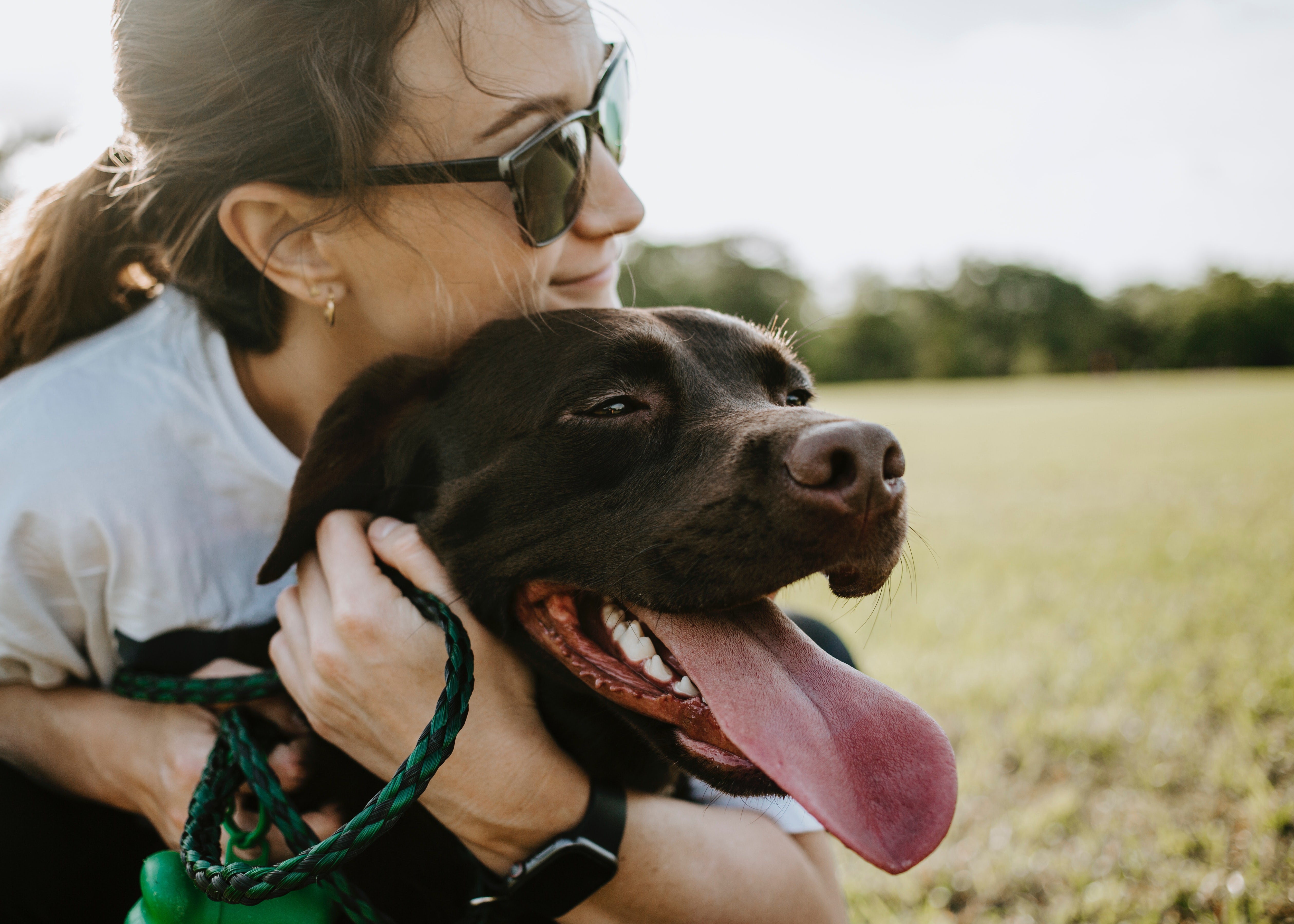 Woman cuddling her dog outside