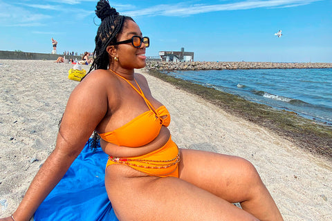 Cristel on the beach in an orange bikini