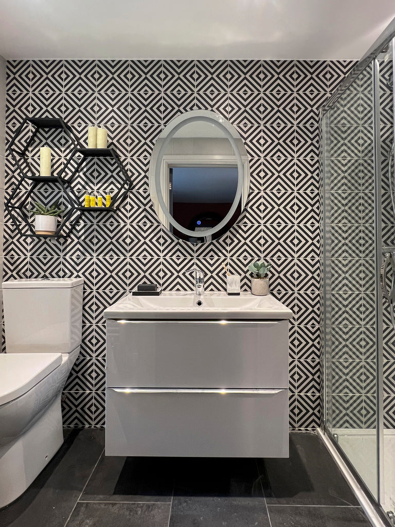 monochrome bathroom with geometrical tiles and wall hung vanity unit and shower