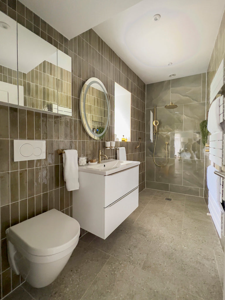 wet room bathroom with wall hung toilet and vanity unit and luxurious marble tiles