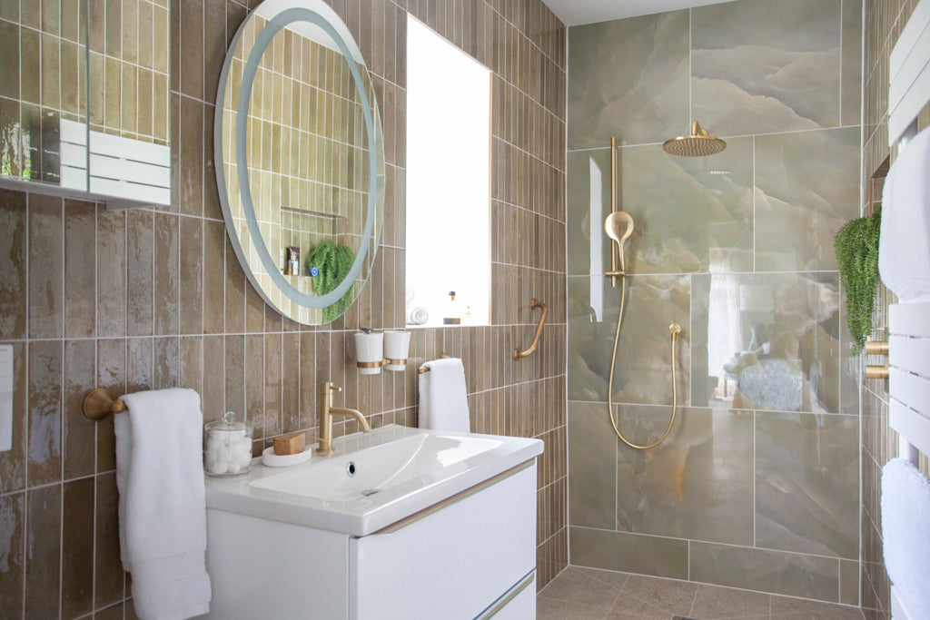 Small wet room with marble tiles and gold fittings featuring a wall hung unit