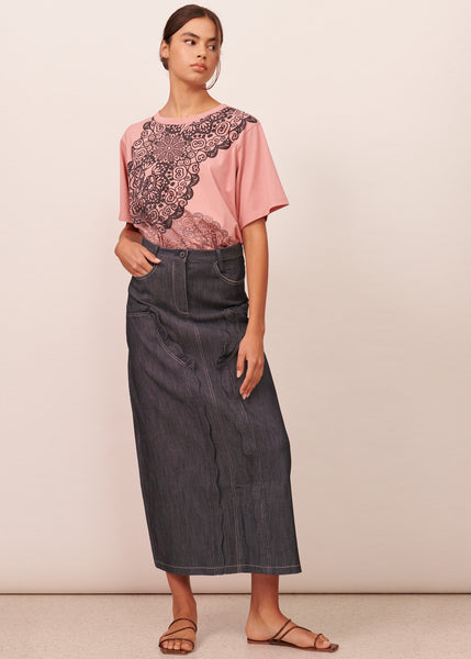 Young woman wearing a pink and navy print tshirt with a dark denim midi skirt