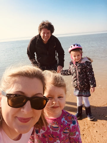 Image of Katie, the Founder of The Mindful Parenting Company with her family on a beach in England in the winter. 