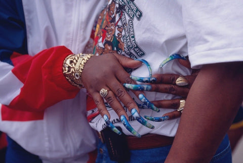 Lady showcasing her blue decorative nail art and gold jewellery