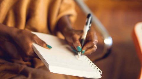 Lady writing down in a notepad