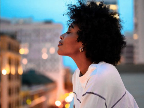 Lady looking content whilst looking out of her balcony