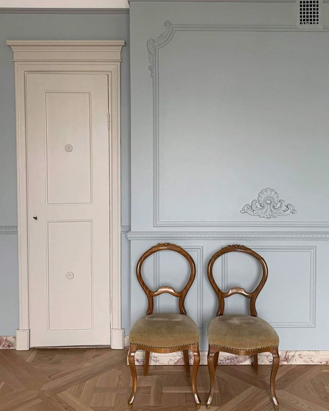 Antique chairs and blue wall