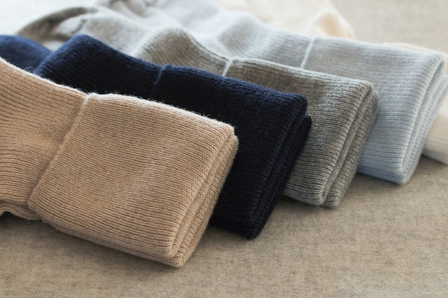 5 pairs of different colored folded cashmere socks in a room